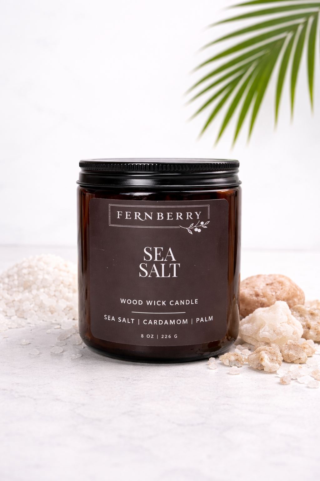 Fernberry Sea Salt candle with sea salt crystals and a leaf on a light background