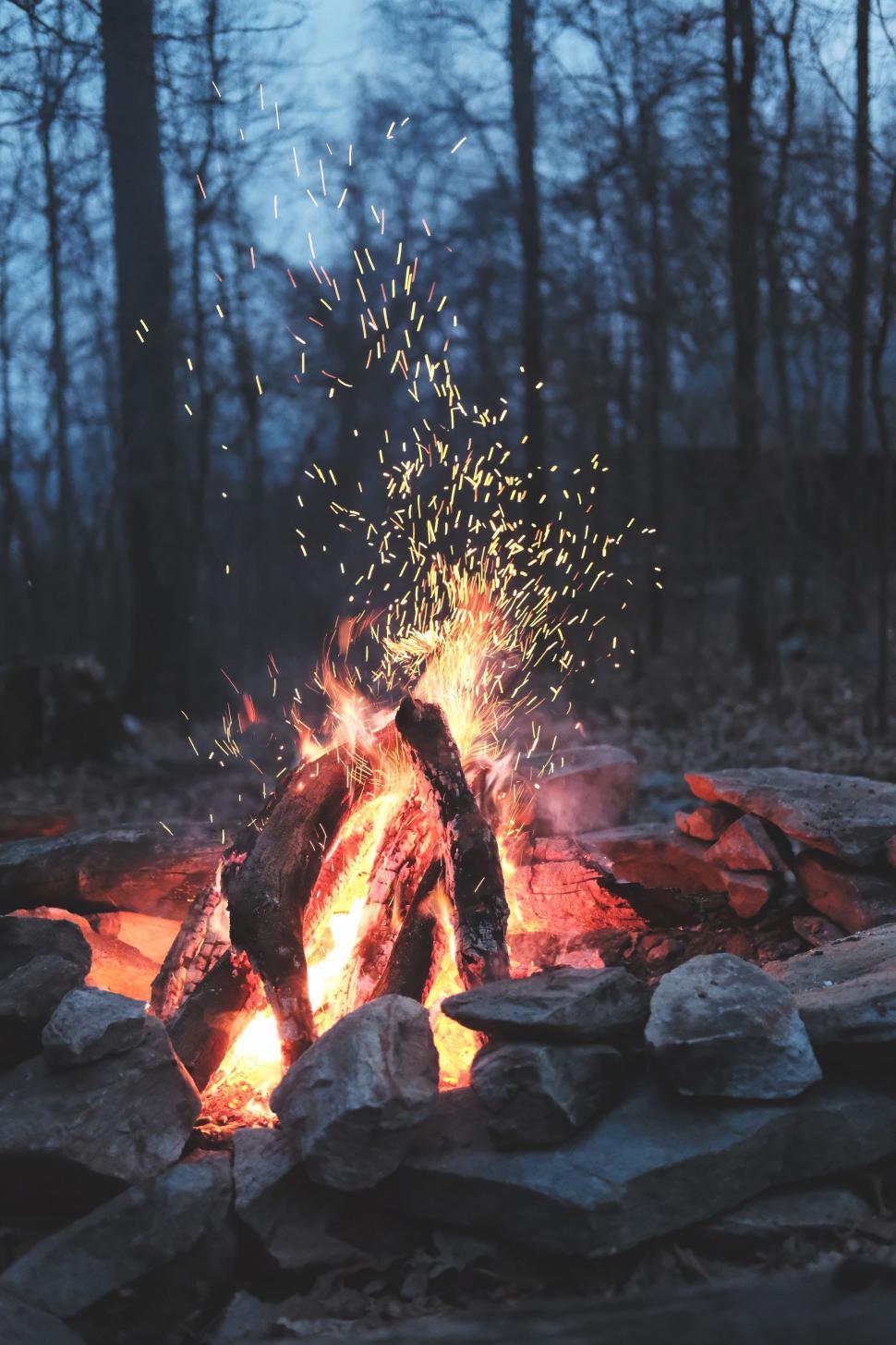 Fire pit with sparks in a forest setting