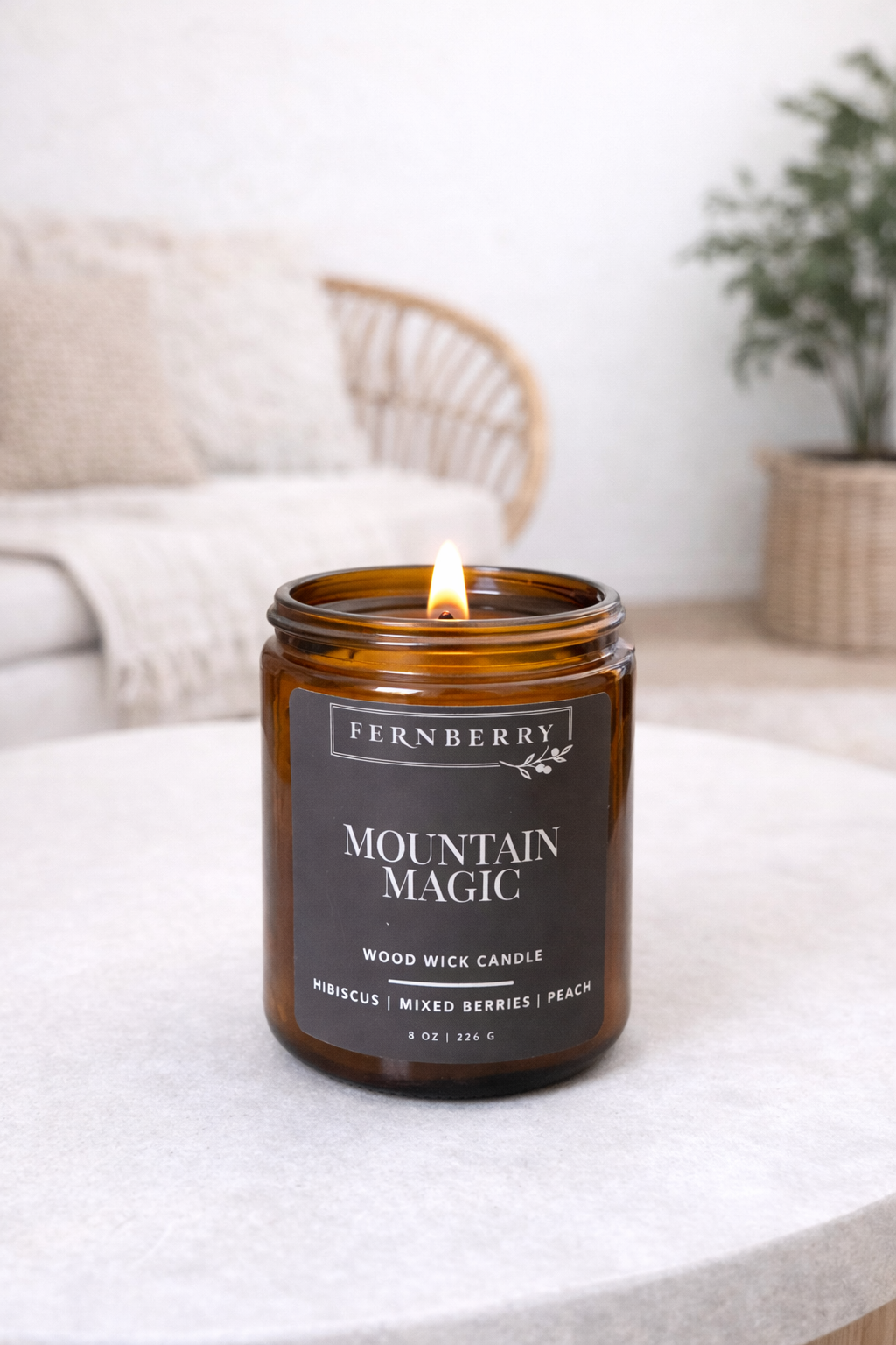 Fernberry Mountain Magic candle on a white surface with a blurred background