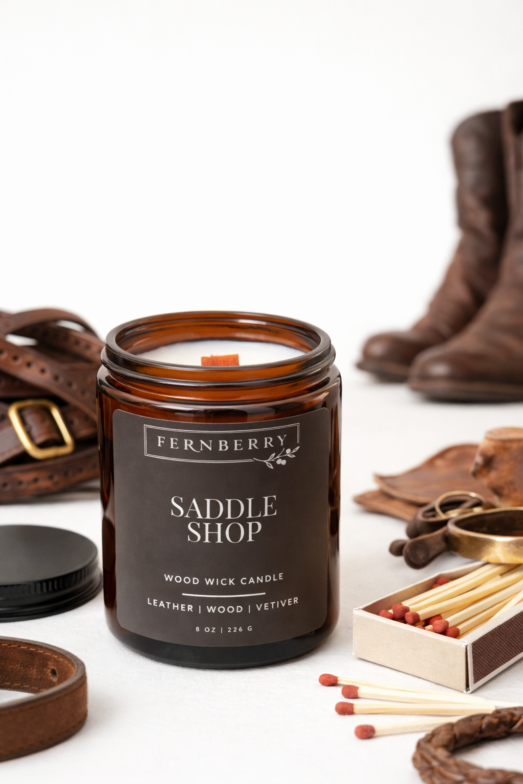 Fernberry Saddle Shop candle with leather accessories on a white background