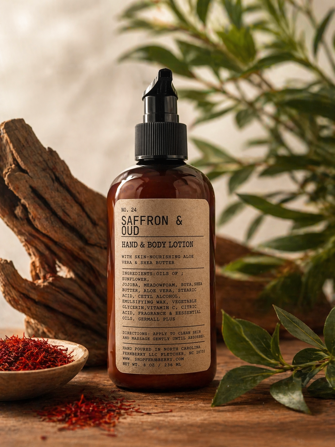 Saffron & Oud hand and body lotion bottle on a wooden surface with saffron and leaves.