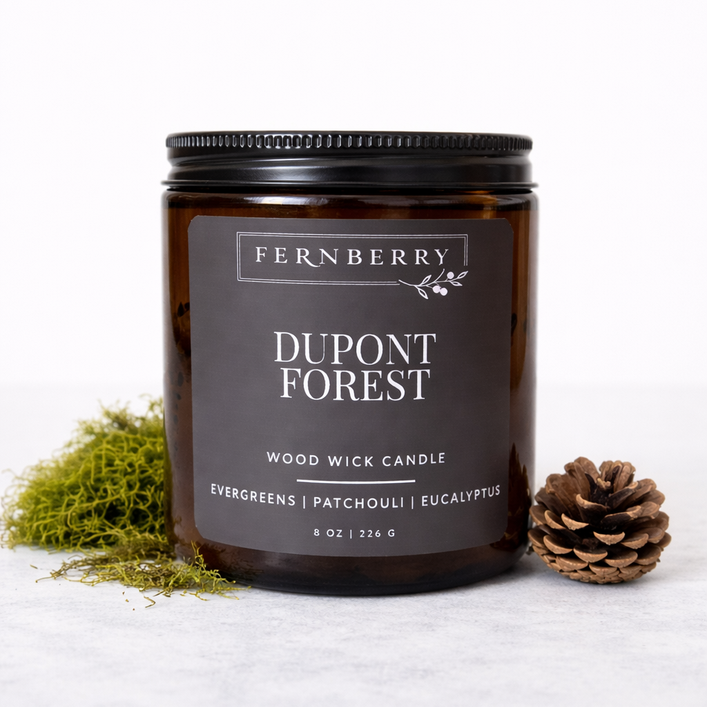 Fernberry Dupont Forest candle with a pine cone and greenery on a white background